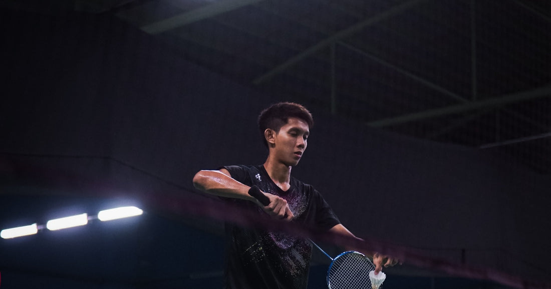 A player at the net on an indoor badminton court